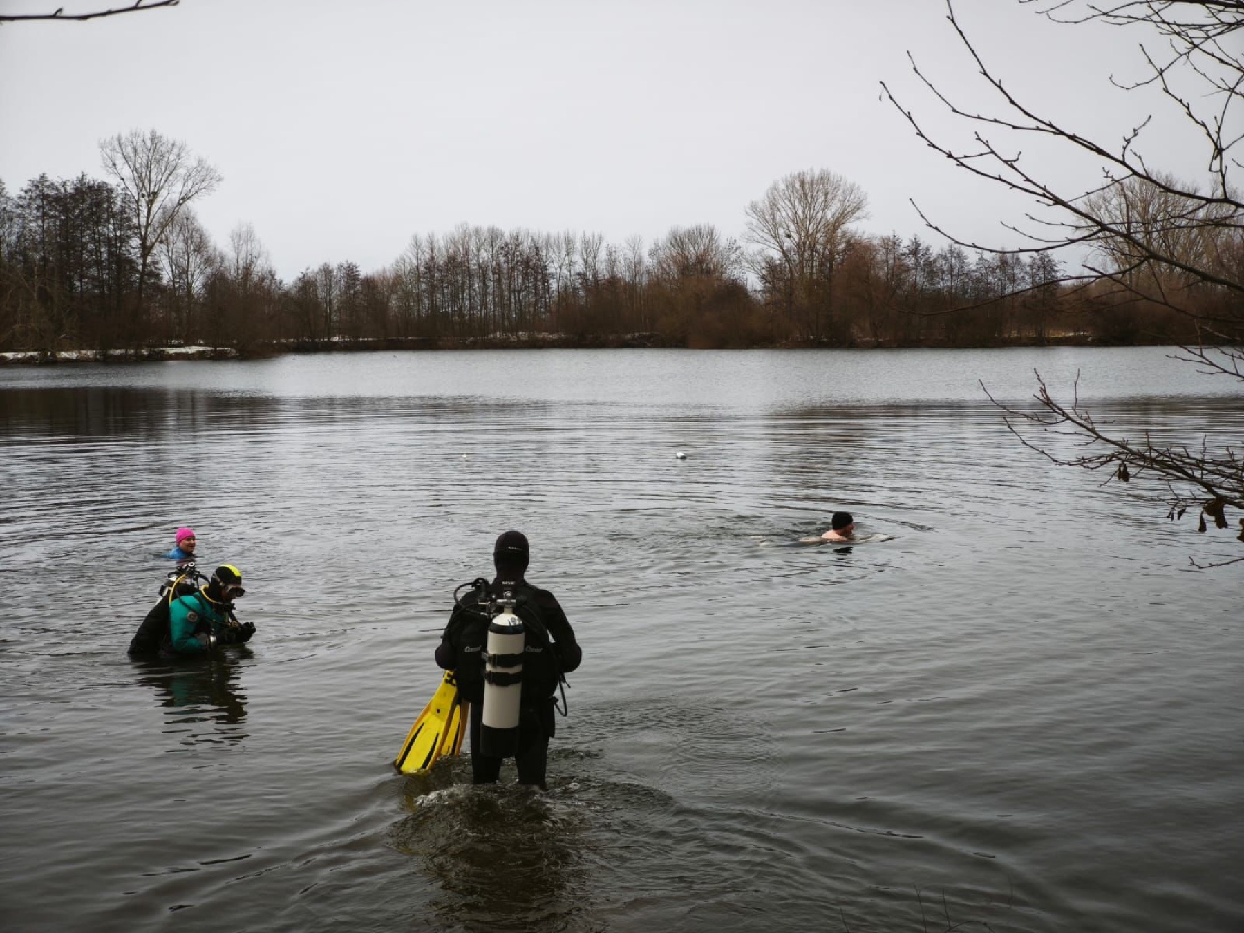 Taucher steigt am verschneiten Ufer des Klein Schneen in den winterlichen See